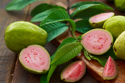 Pink guave with leaves displaying on a table