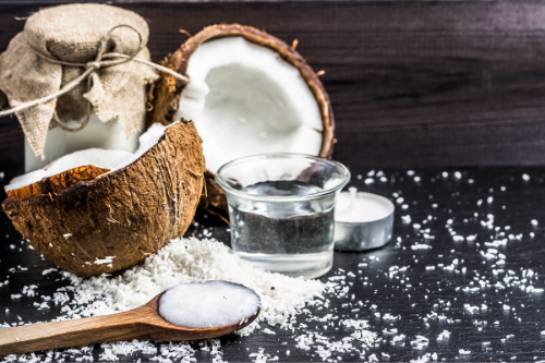 Open coconuts with coconut oil and powder on a table