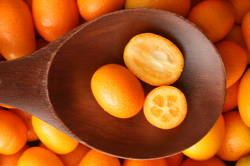 Kumquats fruit in a wooden spoon