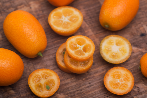 Sliced kumquat fruit laying on a wooden table