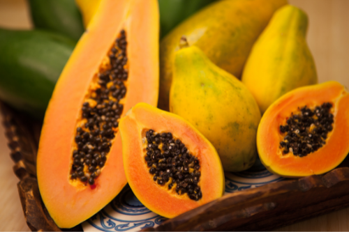 Big and small papaya's laying in a basket