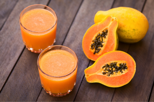 Papaya's and papaya juice on a table